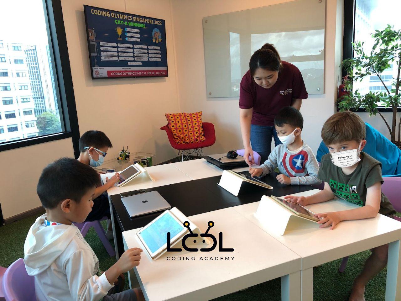 Young students coding on iPads with teacher guidance at LCCL